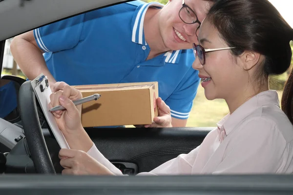 Mujer en el coche firma en el portapapeles para recibir el paquete f — Foto de Stock