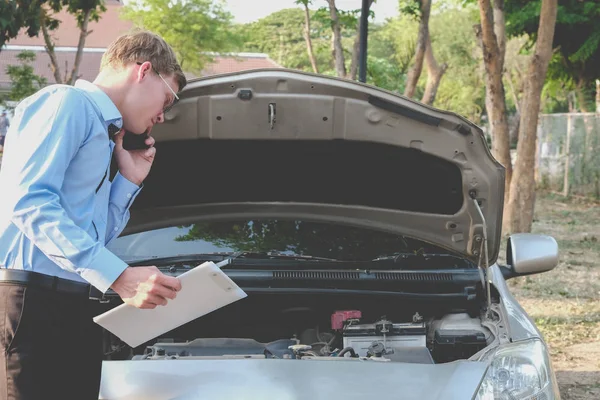 erkek Aracısı otomatik sigorta formu doldurmak için motoru incelenmesi. cau