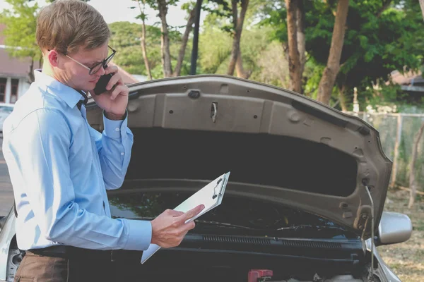 Agente masculino examinando el motor para llenar el formulario de seguro de auto. cau — Foto de Stock