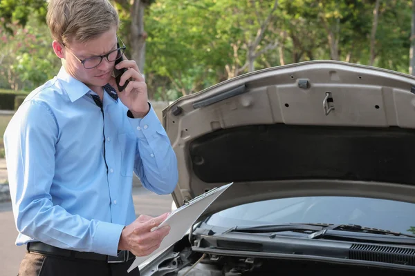 Agente masculino examinando el motor para llenar el formulario de seguro de auto. cau — Foto de Stock