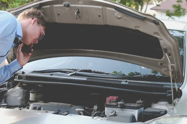 Мужчина-агент проверяет двигатель на наличие авто страховки. caucasi — стоковое фото