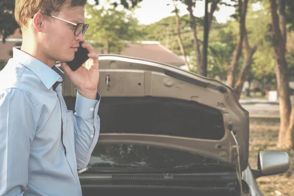 男特工用智能手机认领汽车保险。高加索 — 图库照片