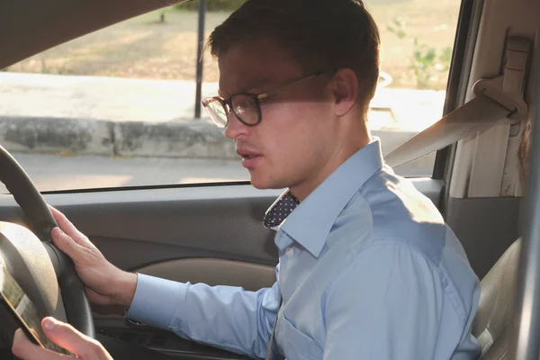 ビジネスマンは、車でのスマート フォンのアプリを使います。男持株モバイル フォー — ストック写真