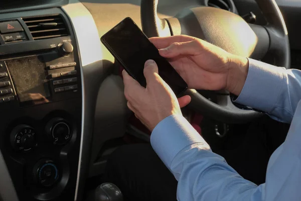商人在汽车上使用智能手机的应用。手持手机的男子 — 图库照片