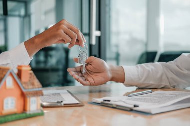 Emlakçı ev anahtarını müşteriye veriyor. Kiralık ev almak