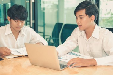 Yatırımcıyla performans gelirlerini analiz eden bir mali danışman. b