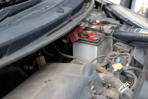 Auto μηχανικός έλεγχος της τάσης της μπαταρίας του αυτοκινήτου από πολύμετρο βολτόμετρο — Φωτογραφία Αρχείου