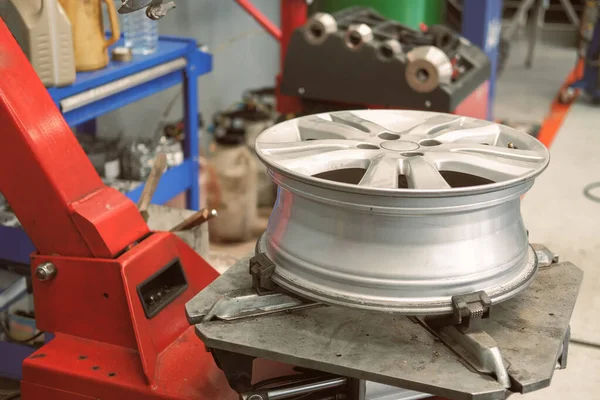 Técnico que quita el caucho del disco de la rueda del coche y del neumático que equilibra —  Fotos de Stock