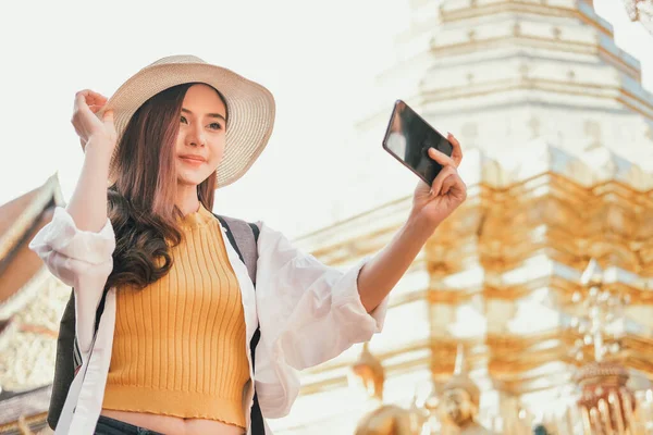 Een vrouw gebruikt een smartphone om foto 's te maken. Reizigers reizen op — Stockfoto