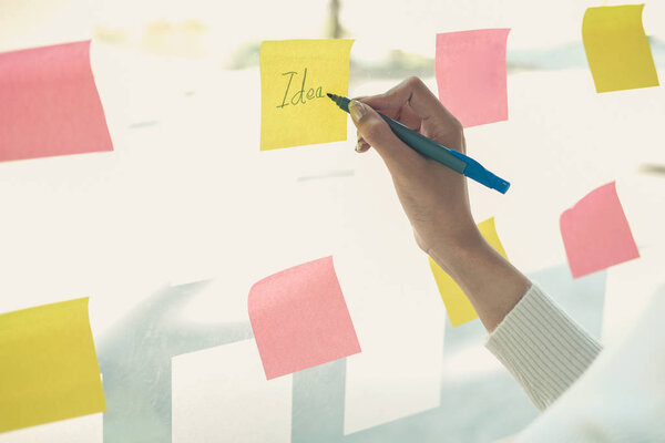 businesswoman woman thinking planning with adhesive notes on gla