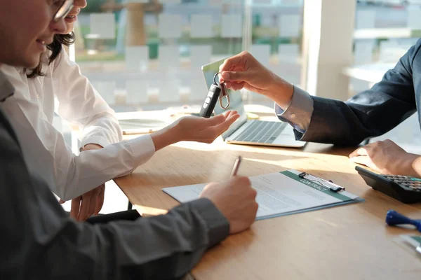 Vendedor de concesionarios dando la llave del coche al propietario. cliente firma insuranc — Foto de Stock
