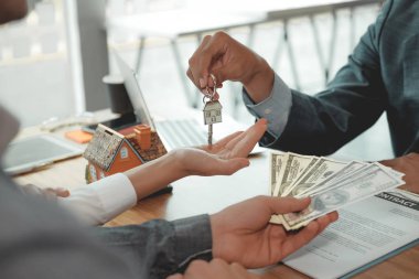 Emlakçı çift müşteriye evin anahtarını veriyor. istemci ödemesi