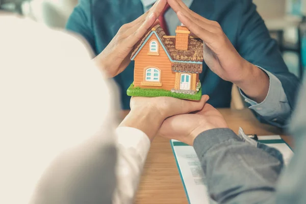 Hand schützendes Hausmodell. Wohngebäudeversicherung, Sicherheit & Sicherheit — Stockfoto