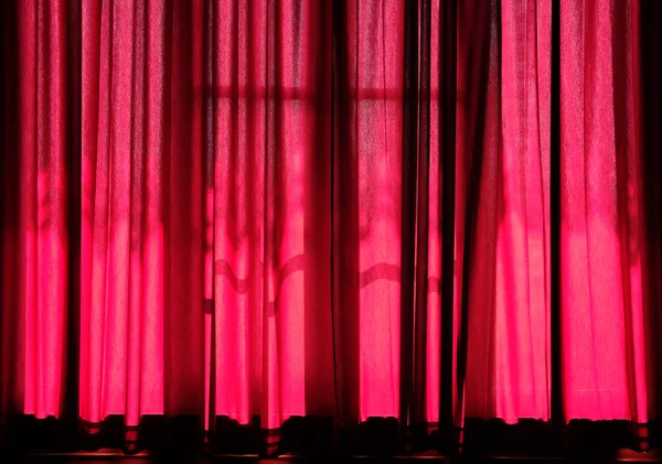 sunlight on red curtain. fabric folds in home interior