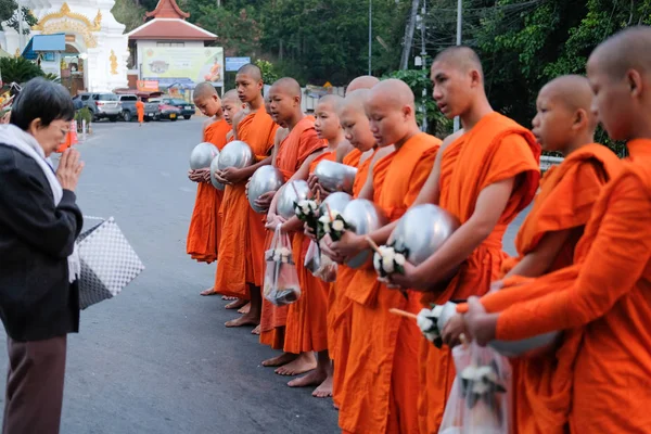 Lidé dávají almužnu jídlo buddhistickému mnichovi — Stock fotografie