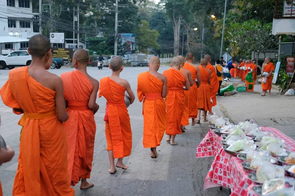 Buddhistický mnich chůzi s miskou přijímat almužnu jídlo od lidí — Stock fotografie