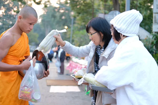 Lidé dávají almužnu jídlo buddhistickému mnichovi — Stock fotografie