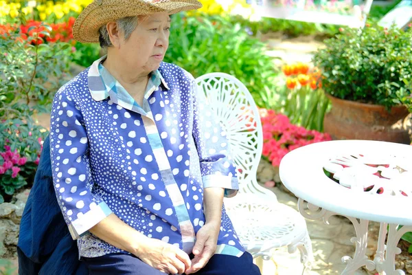 Stara Starsza kobieta odpoczywa w ogrodzie. Starsza kobieta relaksujący prześcignąć — Zdjęcie stockowe