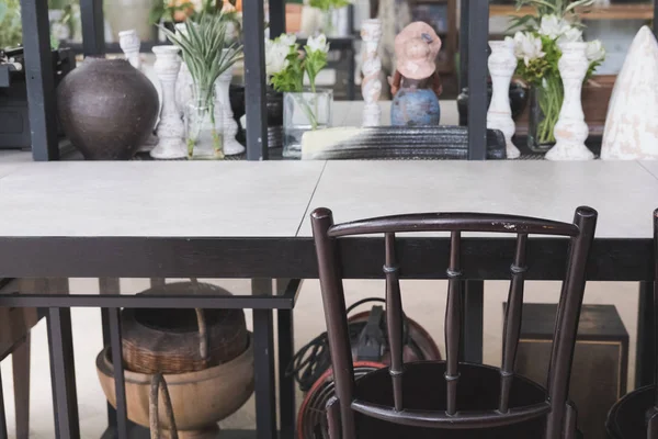 Chaise marron avec table en bois près de l'armoire décorant avec fleur — Photo