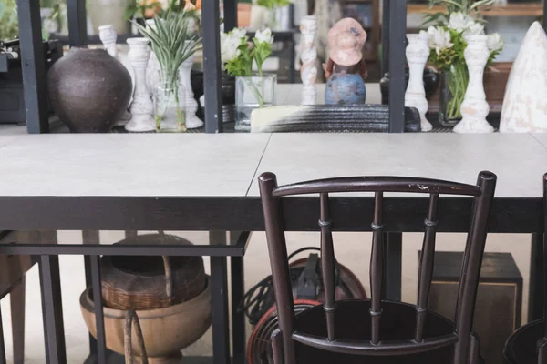 Cadeira marrom com mesa de madeira perto do armário de decoração com flowerp — Fotografia de Stock