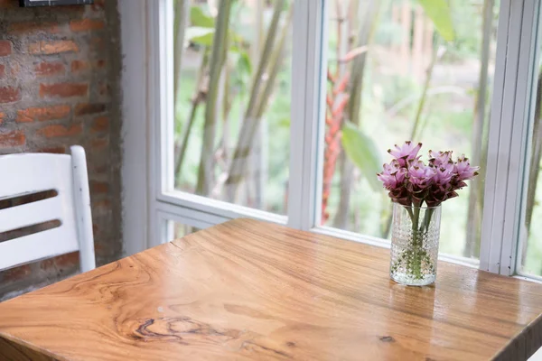 Roze siam tulip bloem in vaas op houten tafel in de buurt van venster. Decora — Stockfoto