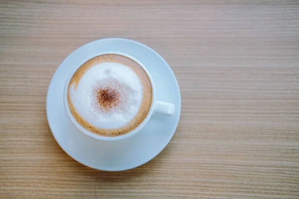 Café de latte cappuccino quente na mesa de madeira . — Fotografia de Stock