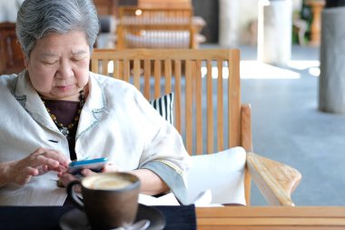 Yaşlı bir kadın cep telefonu kullanıyor. Yaşlı bir kadın.