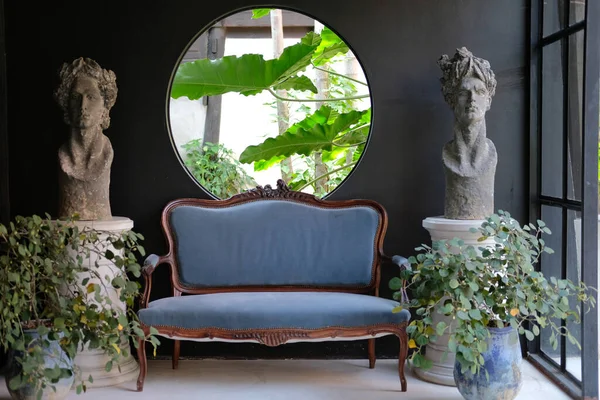 Zielone liście w ogrodzie z niebieską sofą w salonie — Zdjęcie stockowe