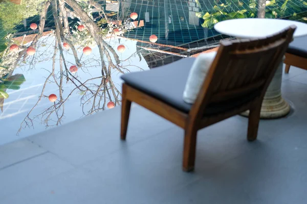 Baumreflexion am Schwimmbad mit Holzstuhl im Hotel für — Stockfoto