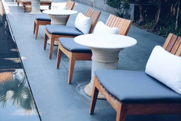 Подушка подушки на деревянном стуле в отеле курорта для отдыха вне — стоковое фото