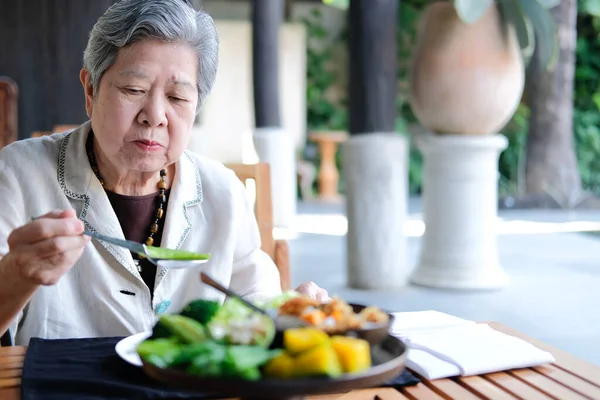 Old elderly senior elder woman eating food. mature retirement li Royalty Free Stock Photos