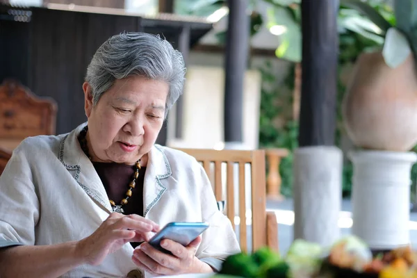 Elder senior woman using mobile smart phone. elderly female hold Royalty Free Stock Images