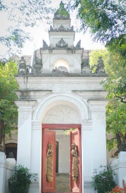 old vintage wooden door arch with asian angle sculpture