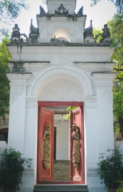old vintage wooden door arch with asian angle sculpture