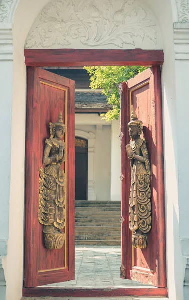 Old vintage wooden door arch with asian angle sculpture — Stok fotoğraf