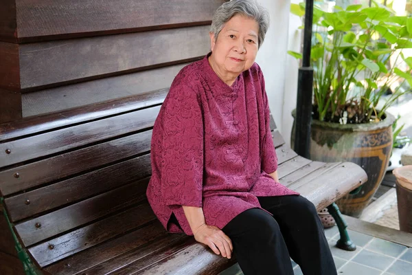 Anciana descansando en el jardín. anciana mujer relajante en pa — Foto de Stock