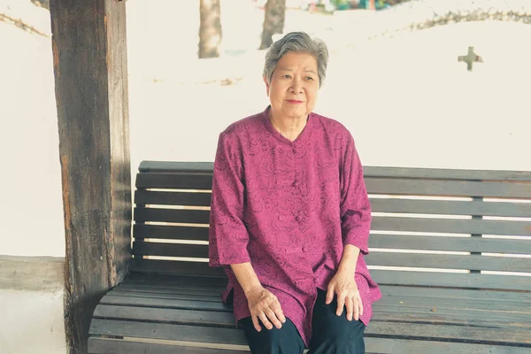 Old elderly senior elder woman resting relaxing on chair at balc — Stockfoto