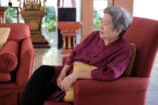 Old elderly senior elder woman resting relaxing on sofa couch in — Stock Photo, Image