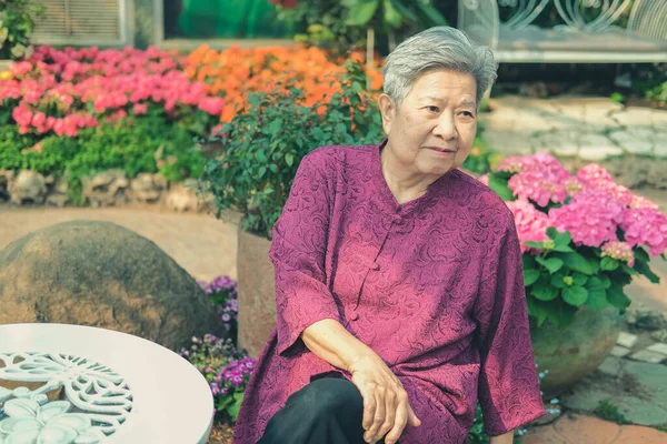 Ηλικιωμένη Γυναίκα Ξεκουράζεται Στον Κήπο Λουλούδια Ασιάτισσα Ηλικιωμένη Γυναίκα Χαλαρώνει — Φωτογραφία Αρχείου