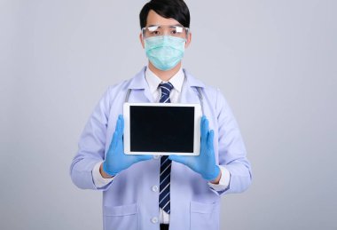 Doktor doktor doktor maske takıyor ve beyaz arka planda tablet ve steteskop var. Tıbbi profesyonel tıp sağlık hizmeti kavramı