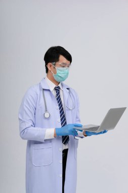 Doktor doktor doktor maske takıyor ve beyaz arka planda bilgisayar ve steteskop var. Tıbbi profesyonel tıp sağlık hizmeti kavramı