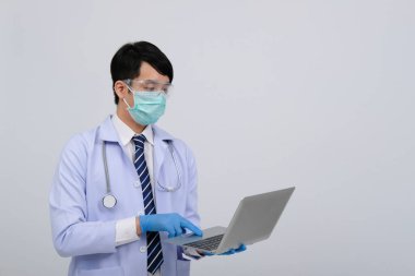 Doktor doktor doktor maske takıyor ve beyaz arka planda bilgisayar ve steteskop var. Tıbbi profesyonel tıp sağlık hizmeti kavramı