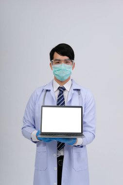 Doktor doktor doktor maske takıyor ve beyaz arka planda bilgisayar ve steteskop var. Tıbbi profesyonel tıp sağlık hizmeti kavramı