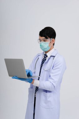 Doktor doktor doktor maske takıyor ve beyaz arka planda bilgisayar ve steteskop var. Tıbbi profesyonel tıp sağlık hizmeti kavramı