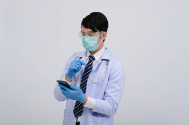 Doktor doktor doktor, maske takıyor ve beyaz arka planda akıllı telefon ve steteskop var. Tıbbi profesyonel tıp sağlık hizmeti kavramı