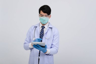 Doktor doktor doktor maske takıyor ve beyaz arka planda tablet ve steteskop var. Tıbbi profesyonel tıp sağlık hizmeti kavramı
