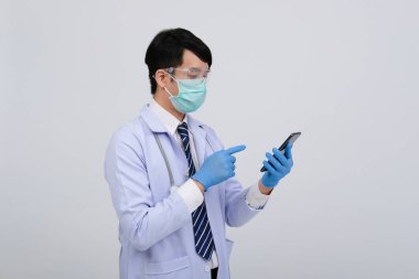 Doktor doktor doktor, maske takıyor ve beyaz arka planda akıllı telefon ve steteskop var. Tıbbi profesyonel tıp sağlık hizmeti kavramı
