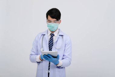 Doktor doktor doktor maske takıyor ve beyaz arka planda tablet ve steteskop var. Tıbbi profesyonel tıp sağlık hizmeti kavramı