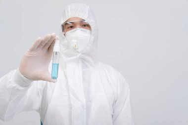 Biyolojik koruyucu üniforma, maske giyen adam doktor. Virüs bakterilerini dezenfekte etmek için el alkolü dezenfektanlı eldivenler.