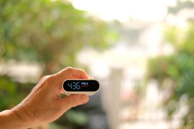 İnsanlar hava kalitesini kontrol etmek için PM 2.5 dedektörüyle el ele tutuşuyorlar. İnce parçacıklardan kaynaklanan hava kirliliği kötü sağlıksız havaya neden olur